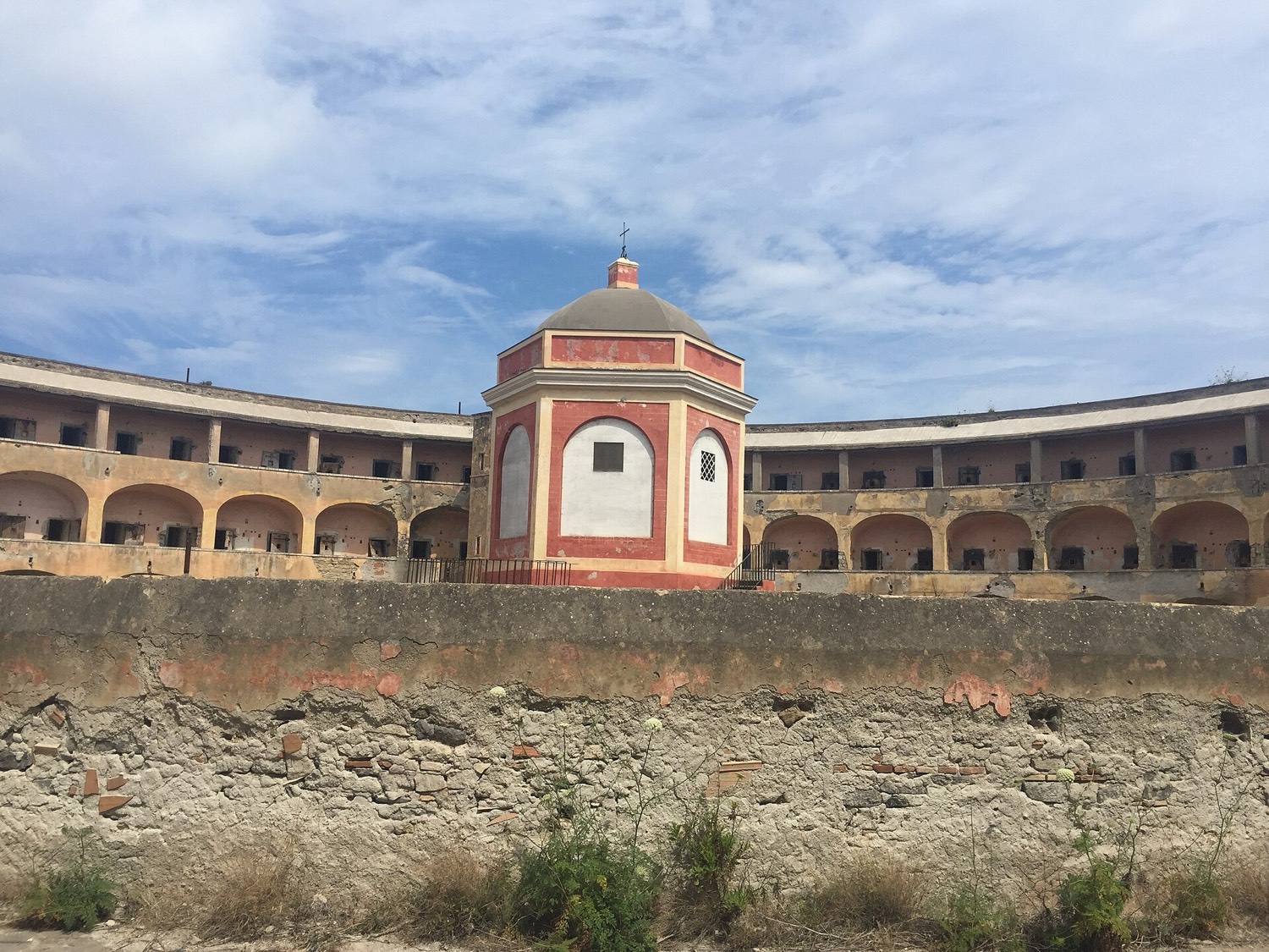 The inner courtyard of the Santo Stefano prison: three tiers of walkways with cells arranged in a horseshoe around an empty space