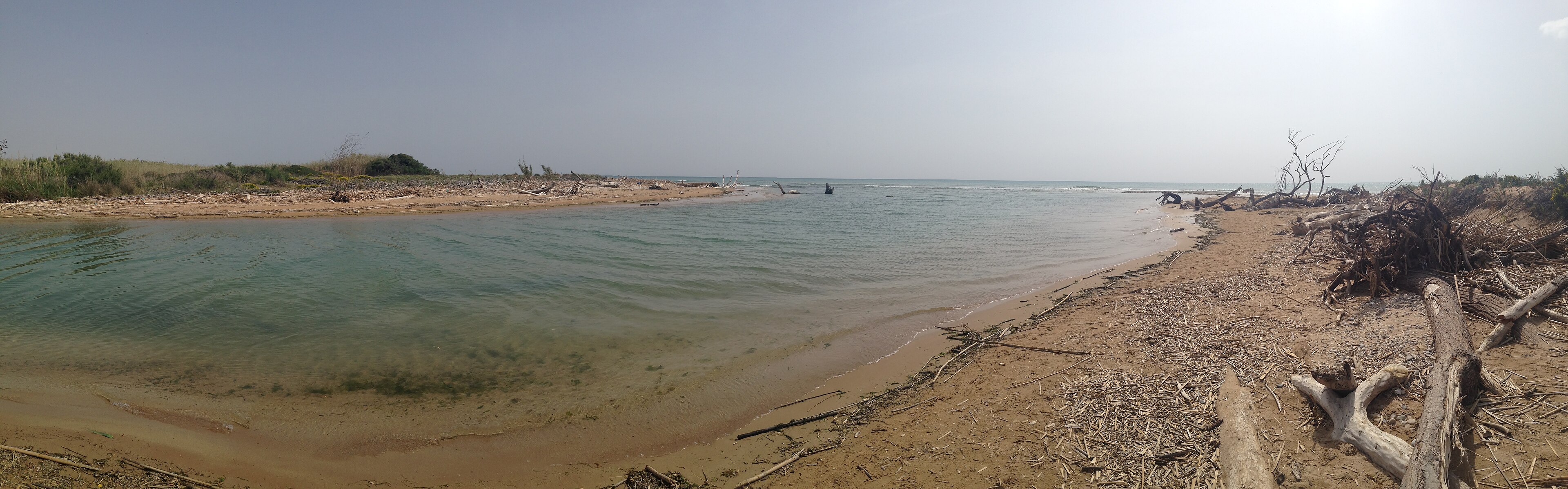Panorama of a Sicilian river mouth: the freshwater bend closed by a sandbar, and beyond the sand the open sea